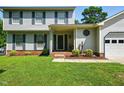 Inviting front porch of a two-story home with manicured lawn and landscaping at 1 Saturn Court Ct, Durham, NC 27703