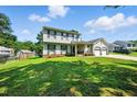 Two-story home with attached two-car garage, lush green lawn, and mature trees at 1 Saturn Court Ct, Durham, NC 27703