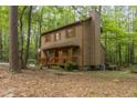 Wood-sided home with a covered front porch and chimney surrounded by lush greenery at 1012 King Cir, Chapel Hill, NC 27516