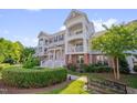 Charming townhome with double balconies, red shutters, lush landscaping, and inviting curb appeal with a park bench at 10330 Sablewood Dr # 104, Raleigh, NC 27617