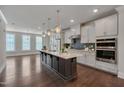 Modern kitchen with stainless steel appliances, spacious island, and stylish lighting fixtures at 10330 Sablewood Dr # 104, Raleigh, NC 27617
