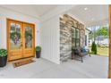 Inviting front porch with stone accents, bench seating, and a welcoming double-door entrance at 1050 Southern High School Rd, Burlington, NC 27215