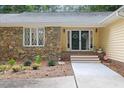 Close up view of the charming front entrance with stone details and a covered entryway at 106 Autumn Cir, Cary, NC 27518