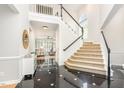 Bright foyer with a grand staircase, black and white tile flooring, and views into the living area at 109 Murdock Creek Ct, Cary, NC 27519