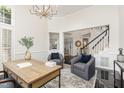 A stylish office space featuring a wooden desk, two armchairs, and a view of the staircase at 109 Murdock Creek Ct, Cary, NC 27519