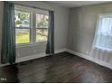Bedroom with hardwood floors, neutral paint, and natural light from the large windows at 1102 N Guthrie Ave, Durham, NC 27703