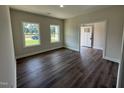 Open living room with hardwood floors, lots of natural light, and a view of the yard at 111 Hot Springs Way, Benson, NC 27504