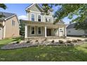 Inviting two-story home featuring a classic covered front porch, columns, and well-maintained landscaping at 1133 Heritage Greens Dr, Wake Forest, NC 27587