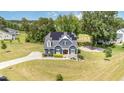 Stunning aerial view of a two-story home with a well-manicured lawn, solar panels, and a long driveway at 119 Florentino Ct, Clayton, NC 27527