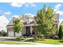 Attractive brick home with a well-kept lawn, a two-car garage, and a welcoming front porch at 1217 Clandon Square Rd, Hillsborough, NC 27278