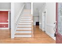 Inviting foyer featuring hardwood floors and staircase, complemented by neutral wall paint at 1230 Sykes Rd, Spring Hope, NC 27882