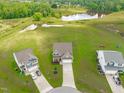Stunning aerial view of home with well-manicured lawn and adjacent ponds at 124 Lahinch Dr, Fuquay Varina, NC 27526