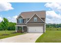 Charming two-story home with a well-kept lawn and a convenient two-car garage with ample parking space at 124 Lahinch Dr, Fuquay Varina, NC 27526
