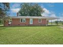 Inviting brick ranch featuring a well-manicured lawn and ample parking at 1308 Tyson Loop Rd, Spring Hope, NC 27882