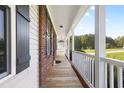 Inviting covered front porch featuring classic wood flooring and elegant railing at 139 His Way, Middlesex, NC 27557