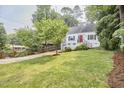 Charming home boasts a well-manicured lawn, bright red door, and attached garage at 1516 Edgevale Rd, Durham, NC 27701