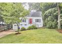 Charming home boasts a well-manicured lawn, bright red door, and attached garage at 1516 Edgevale Rd, Durham, NC 27701