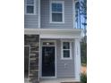 New construction home features a gray facade with white trim around the black front door and adjacent windows at 1524 Chirping Bird Ct, Cary, NC 27519