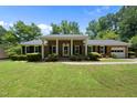 Beautiful brick home with a lush green lawn, classic black shutters, and a covered front entry at 1601 Redmond Dr, Durham, NC 27712