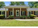 Inviting front porch with brick facade, white columns, and well-maintained landscaping at 1601 Redmond Dr, Durham, NC 27712
