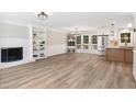 Spacious living room features a brick fireplace, modern lighting, an open floorplan and eat-in kitchen at 1609 Falls Ct, Raleigh, NC 27615
