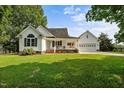 Charming white home with a welcoming front porch, attached garage, and a well-maintained lawn at 2856 Gwyn Rd, Elon, NC 27244