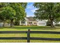Well-maintained white home with front porch and attached garage, set back on a spacious green lawn at 2856 Gwyn Rd, Elon, NC 27244
