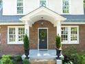 Close up of entryway with wreath on the door, brickwork, and decorative planters at 304 Polk St, Raleigh, NC 27604