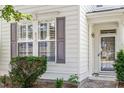 Close up of a front exterior with white siding and gray shutters surrounding large windows near a front door at 3147 Rapid Falls Rd, Cary, NC 27519