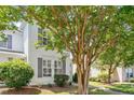 Inviting front exterior of a townhouse with white siding, gray shutters, and lush green landscaping at 3147 Rapid Falls Rd, Cary, NC 27519