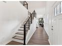 Inviting foyer with hardwood floors, a staircase with modern railings, and bright natural light at 3194 Retama Run, New Hill, NC 27562