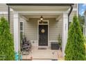 Inviting covered front porch with decorative plants and seating area, perfect for relaxing at 321 Conrad Ln, Wake Forest, NC 27587