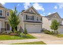 Charming two-story home featuring gray siding, black shutters, and a well-manicured lawn and landscaping at 3224 Star Gazing Ln, Durham, NC 27703