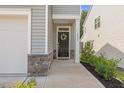 Inviting front entrance with a black door, decorative wreath, stone accents, and manicured shrubs at 3224 Star Gazing Ln, Durham, NC 27703