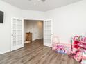 Bright bedroom with French doors, neutral walls, wood floors, and toys at 3292 Longpine Rd, Burlington, NC 27215