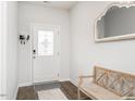 Bright entryway with white door with glass insert, wooden bench, wood floors, and decorative mirror at 3292 Longpine Rd, Burlington, NC 27215