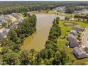 Aerial view showcasing a serene lake surrounded by lush greenery and charming neighborhood homes at 3417 Cardinal Lake Dr, Durham, NC 27704