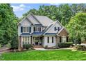 Charming two-story home featuring manicured lawn, brick and siding, and mature trees on a sunny day at 3748 Westbury Lake Dr, Raleigh, NC 27603