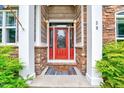 Inviting front entrance with a red door, stone accents, and decorative lighting at 39 Westover Ct, Sanford, NC 27332