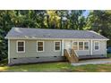 Inviting single-story home with light green siding, gray roof, and wood-finished stairs leading to the front entrance at 41 Andrea Ct, Sanford, NC 27332