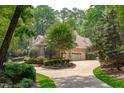 Brick home with a two-car garage surrounded by mature trees and landscaping at 4905 Ivercroft Pl, Fuquay Varina, NC 27526
