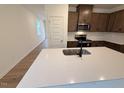 Modern kitchen with a large island, stainless steel sink, and an open view into the living area at 507 Eastwood St, Durham, NC 27704