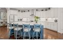Bright kitchen featuring an oversized island, white cabinets, and stainless steel appliances, ideal for cooking and entertaining at 521 Morning Oaks Dr, Holly Springs, NC 27540