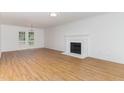 Bright living room showcasing hardwood floors and a decorative fireplace, offering a cozy and inviting atmosphere at 5429 Fortunes Ridge Dr, Durham, NC 27713