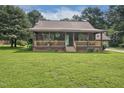Rustic log home featuring a covered front porch, natural landscaping, and a tranquil setting at 5593 Leon Rd, Nashville, NC 27856