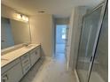 Bright bathroom featuring double vanity, white marble floors and large glass enclosed shower at 57 Blanton Ct, Lillington, NC 27546