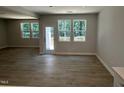 Open living room with wood floors, and many windows with peaceful outdoor views at 57 Blanton Ct, Lillington, NC 27546