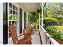 Relaxing front porch with wooden rocking chairs and a view of the lush green landscape at 5833 Dahlberg Dr, Raleigh, NC 27603