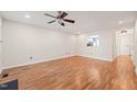 Open living room with wood floors, a ceiling fan, and a pass-through to the kitchen at 6051 Epping Forest Dr, Raleigh, NC 27613