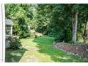 Large backyard with mature trees and a well-maintained lawn at 6205 Remington Lake Dr, Raleigh, NC 27616